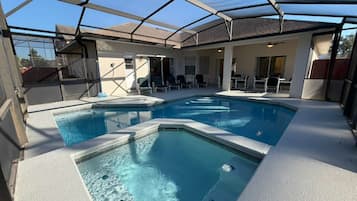 Una piscina cubierta, sombrillas, tumbonas