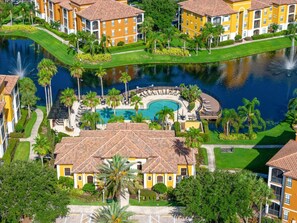 Un complejo turístico con varias edificaciones amarillas, una piscina central y un cuerpo de agua circundante.