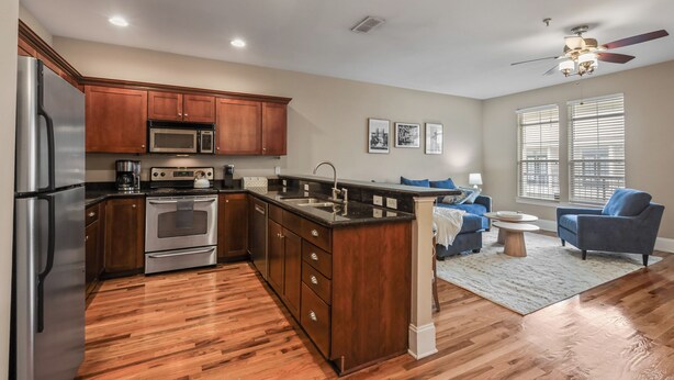 A modern kitchen with wooden cabinets, stainless steel appliances, and a central island.