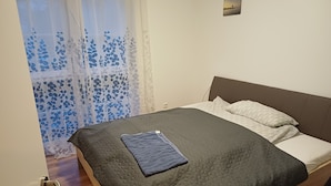 Une chambre à coucher avec un lit, une fenêtre donnant sur un beau paysage et une porte.