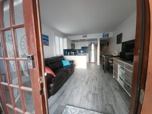A compact living space with a kitchenette, a sofa, and a television. - Step out the door with toes in the sand and a drink in your hand! (Indian Shores)
