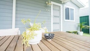 Une table en bois sur laquelle se trouvent un pot blanc et un bol aux motifs noirs et blancs.
