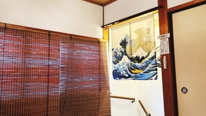 A traditional Japanese room with tatami flooring, a shoji screen, a hanging light fixture, and a sliding door with a decorative painting. - Namba 13 min｜6 min walk from station｜Wi-Fi｜Nintendo Switch｜48 m2 private house｜10 min walk from Tsutenkaku (大阪市)