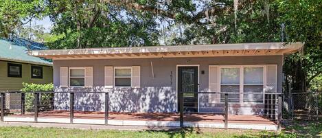 A small, single-story building with a flat roof, a front door, and a small porch area.
