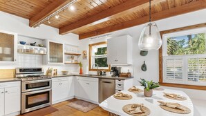 A modern kitchen with white cabinets, stainless steel appliances, and a wooden ceiling. - Langoon Lodge 4-BR 3-BA, 8 beds. Walk to DT&Lake (Mount Dora)