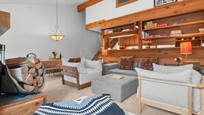 A cozy living room with a fireplace, wooden bookshelves, and comfortable seating. - RMR: Alpine Fir 722 Condo in The Aspens/Wilson, WY (Wilson)