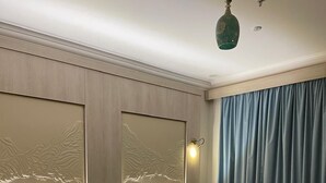 A hotel room with two beds, a large mirror, and a view of the mountains through the window. - The High View (Al Baha)