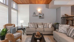 Un salon comprenant un canapé, des fauteuils, une table basse et une cheminée.