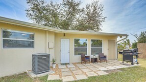 Une maison avec un patio, un barbecue et un appareil de climatisation.