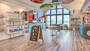 A cafe with a self-serve station, seating area, and a view of the ocean. - Resort Perks & Family Fun! St George Retreat (St. George)