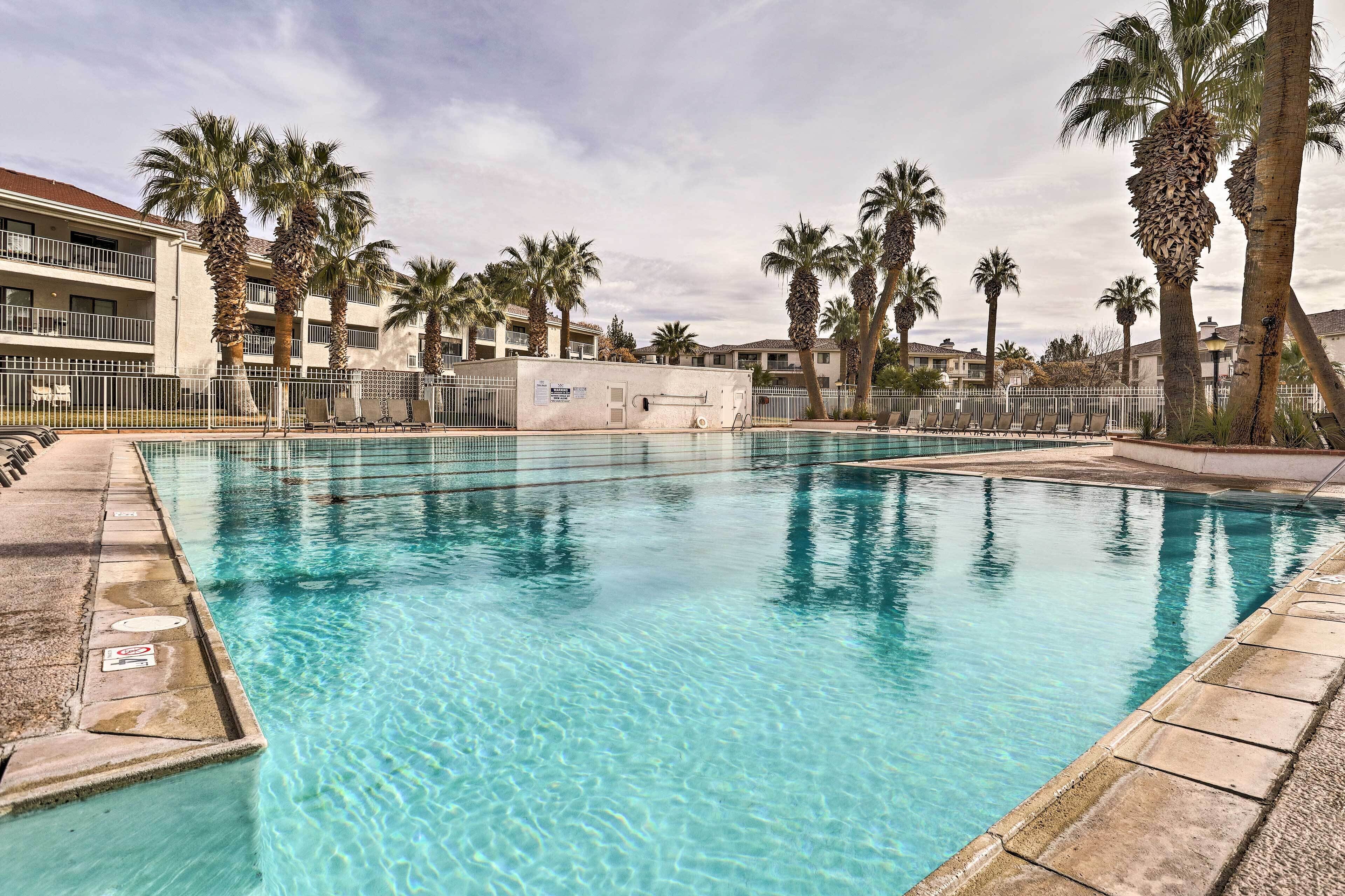 Una piscina cristalina rodeada de palmeras y un edificio con balcones.