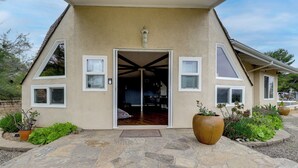 Una casa con entrada empaveda de piedra, una puerta grande y plantas en macetas.