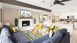 Una sala de estar moderna con chimenea, un sofá, una mesa de centro y un televisor.