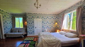 Una habitación con cama, sofá, puerta y ventana.
