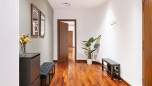 A hallway with wooden flooring, a bench, a potted plant, and framed artwork on the wall. - Easylife - Milan - italia 11 P4 - Historic Center (Milano)