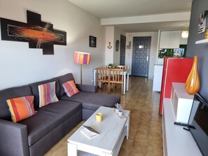 Un salon comprenant un canapé, une table basse et un coin repas avec des chaises et une table.