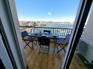 A balcony with a table set for four, overlooking a marina and cityscape. - Apartment with private terrace in L'Escala, near the beach (L'Escala)