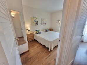 A bedroom with a bed, bedside tables, a mirror, and wall art. - Cozy apartment near the beach with air conditioning (L'Escala)