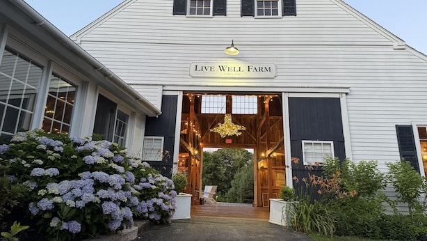 A white building with a sign reading "Live Well Farm" and a wooden interior visible through the entrance. - A rambling farmhouse, now a modern and comfortable sanctuary for you to enjoy! (Harpswell)
