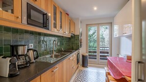 Una cocina moderna con armarios de madera, un microondas de acero inoxidable y una cafetera.