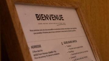 Un cartel de bienvenida con secciones tituladas 'ACCESSE', 'QUELQUES INFOS', 'NOUS CONTACTE' y 'GÉNÉRALITÉS'.