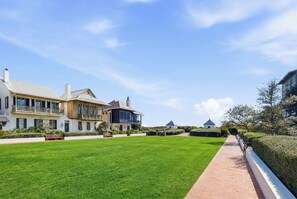 A residential property with a well-maintained lawn, a brick pathway, and a large house with multiple balconies and a garage. - Rosemary Beach | Sleeps 6 | Seaglass At Rosemary | Pools | Balcony (Rosemary Beach)