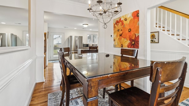 A dining room with a large wooden table, chairs, and a chandelier. - Old Town Retreat in Historic Fredericksburg (Fredericksburg)