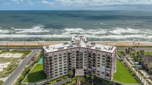 Un hôtel de grande hauteur, avec de nombreux étages, une piscine sur le toit et une vue sur l’océan.