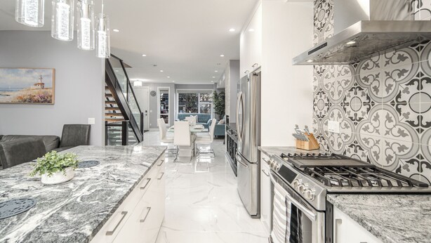 A modern kitchen with a marble countertop, stainless steel appliances, and a patterned backsplash. - 👑Luxury Inner City New Built /Garage /AC/EV Charger (Calgary)