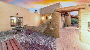 A courtyard with a stone staircase, a fountain, and a wooden bench. - Private, Peaceful, and Spacious Desert Tucson Villa with Heated Pool and Hot Tub (Tucson)