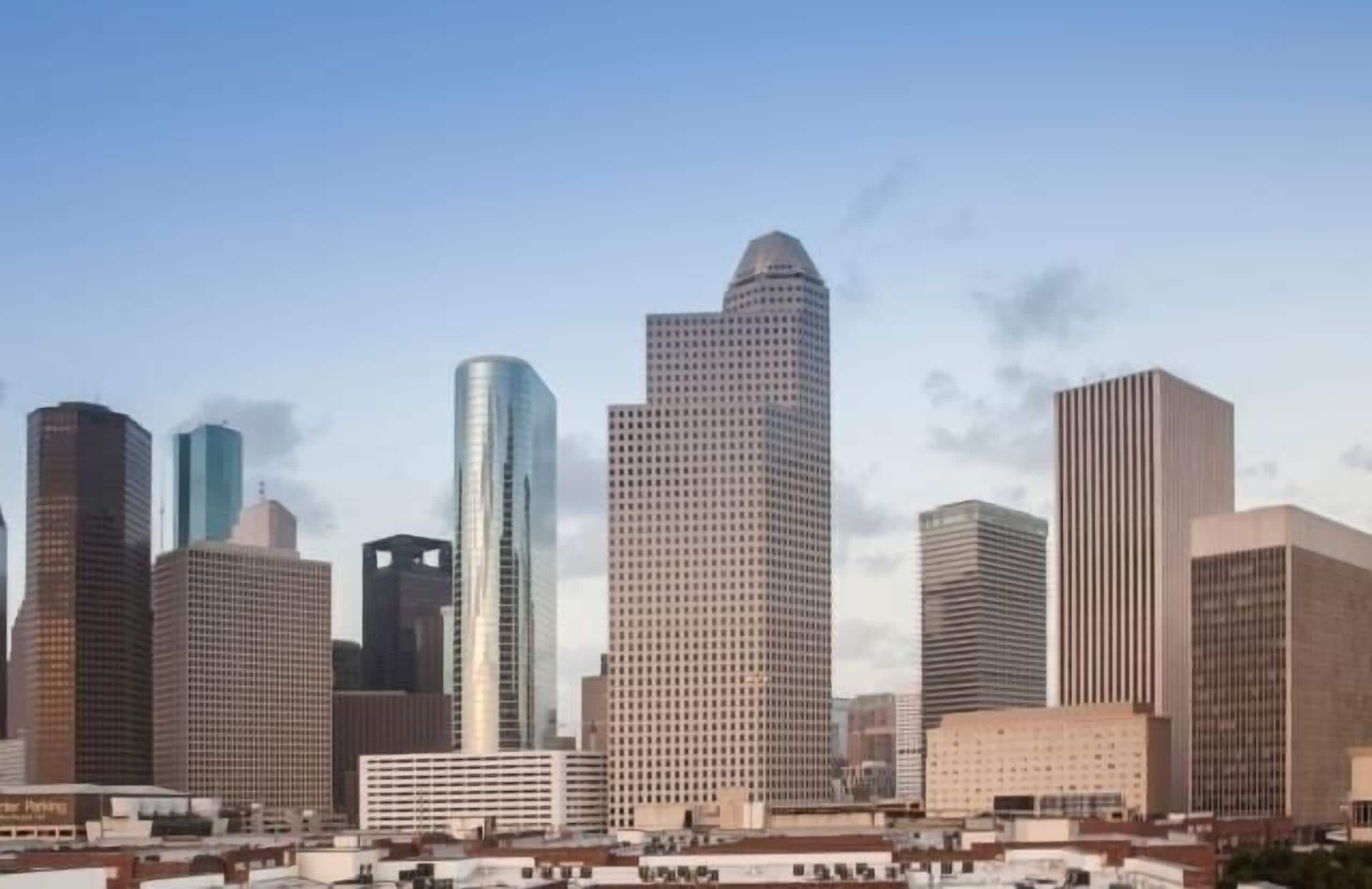 A cityscape with a variety of high-rise buildings, including a prominent skyscraper with a unique pointed top.