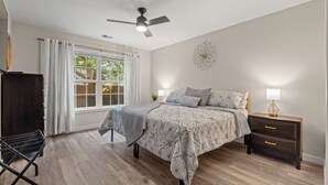 Une chambre à coucher avec un lit, des tables de chevet, un bureau et une chaise.