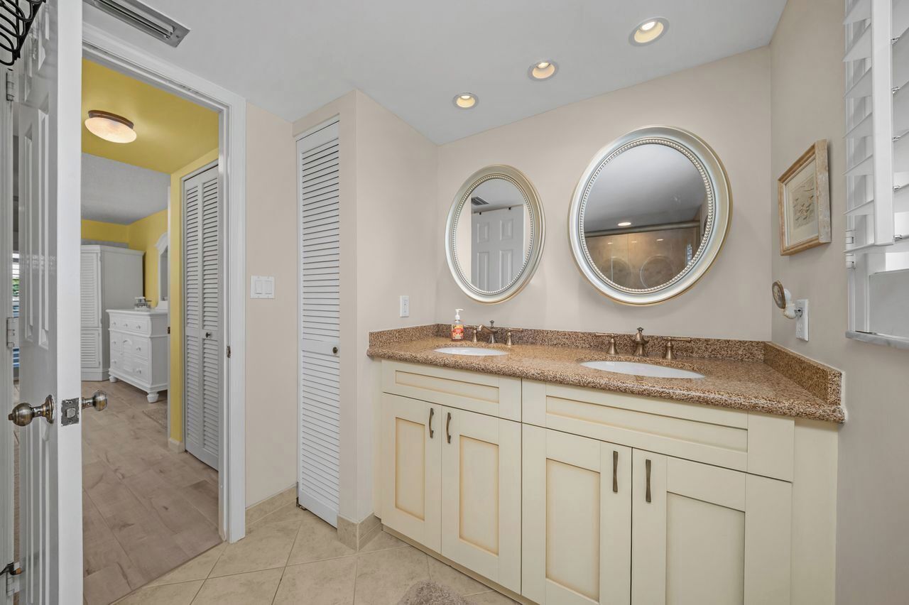 A bathroom with two sinks, a vanity, and two wall-mounted mirrors.