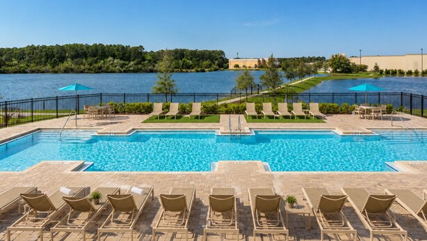 Une piscine avec des chaises longues et vue sur un lac.