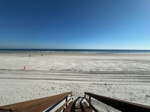 A beach with a wooden walkway leading to the water, footprints in the sand, and a clear sky. - Superb 1-bedroom Garage Apt on Oceanfront Property St Augustine/Crescent Beach (St Augustine)