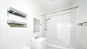 Ein Badezimmer mit einer weißen Badewanne, einem Waschbecken und einem Spiegel.