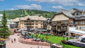 A hotel with multiple floors, outdoor seating, and a view of a mountain. - Park Plaza Condo W/Resort Amenities (Beaver Creek)