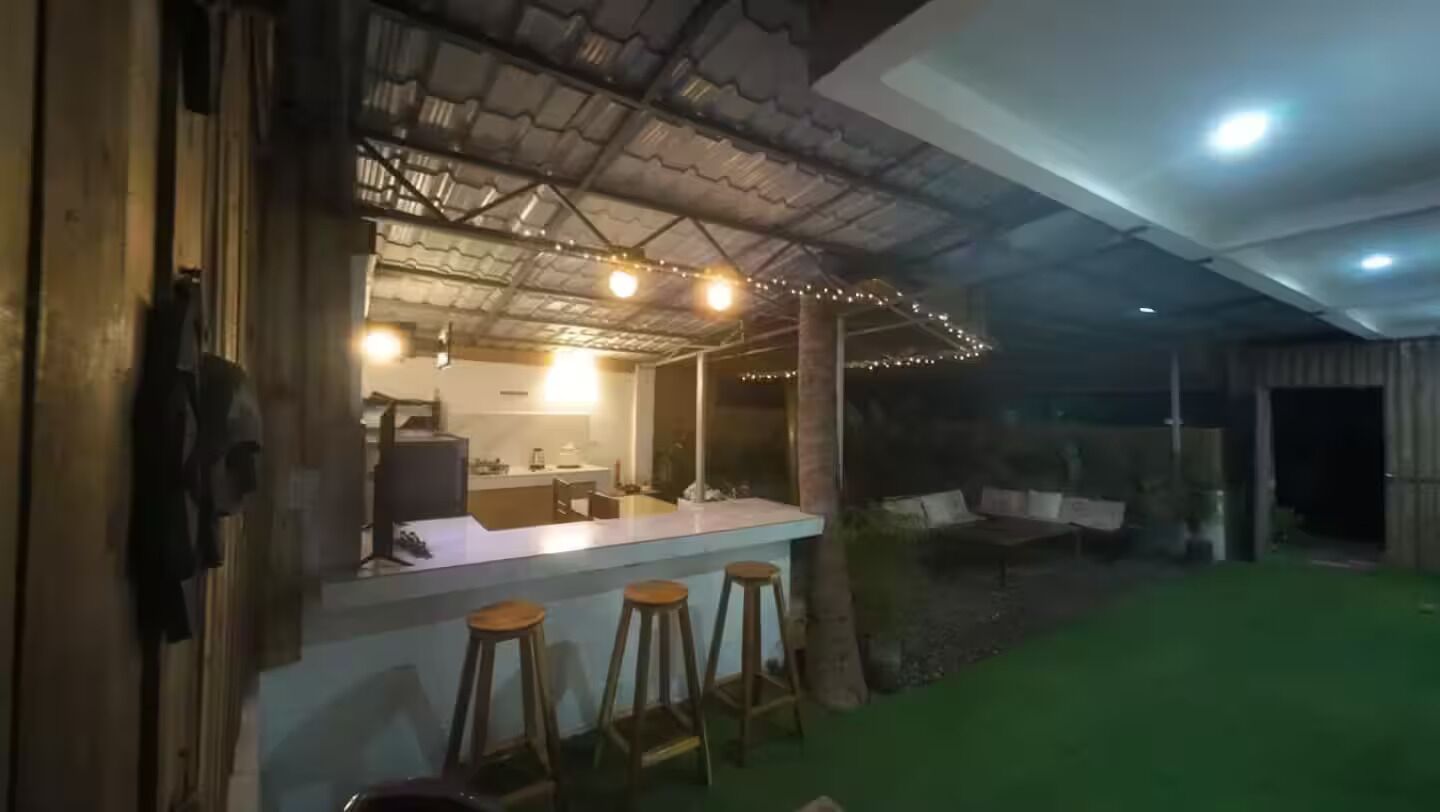 A bar area with stools, a counter, and string lights.