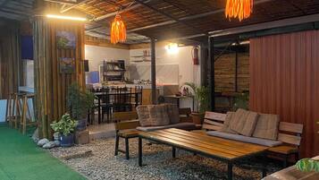An indoor space with a seating area, a kitchen, and a dining area.