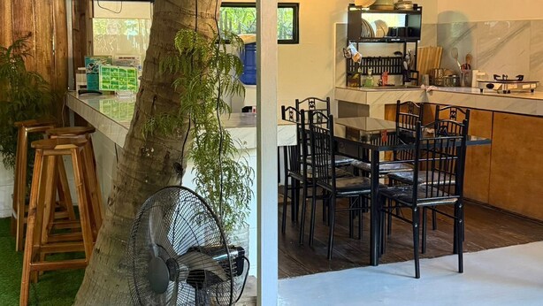 A rustic kitchen with a dining area, a fan, and a tree trunk centerpiece. - Amazing property in (El Nido)