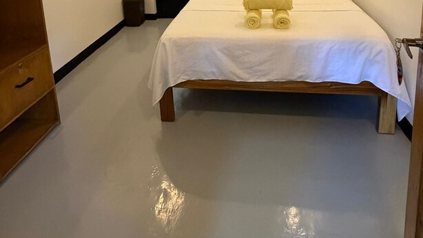 Una habitación de hotel con una cama, un armario de madera y una puerta que da a otra habitación.