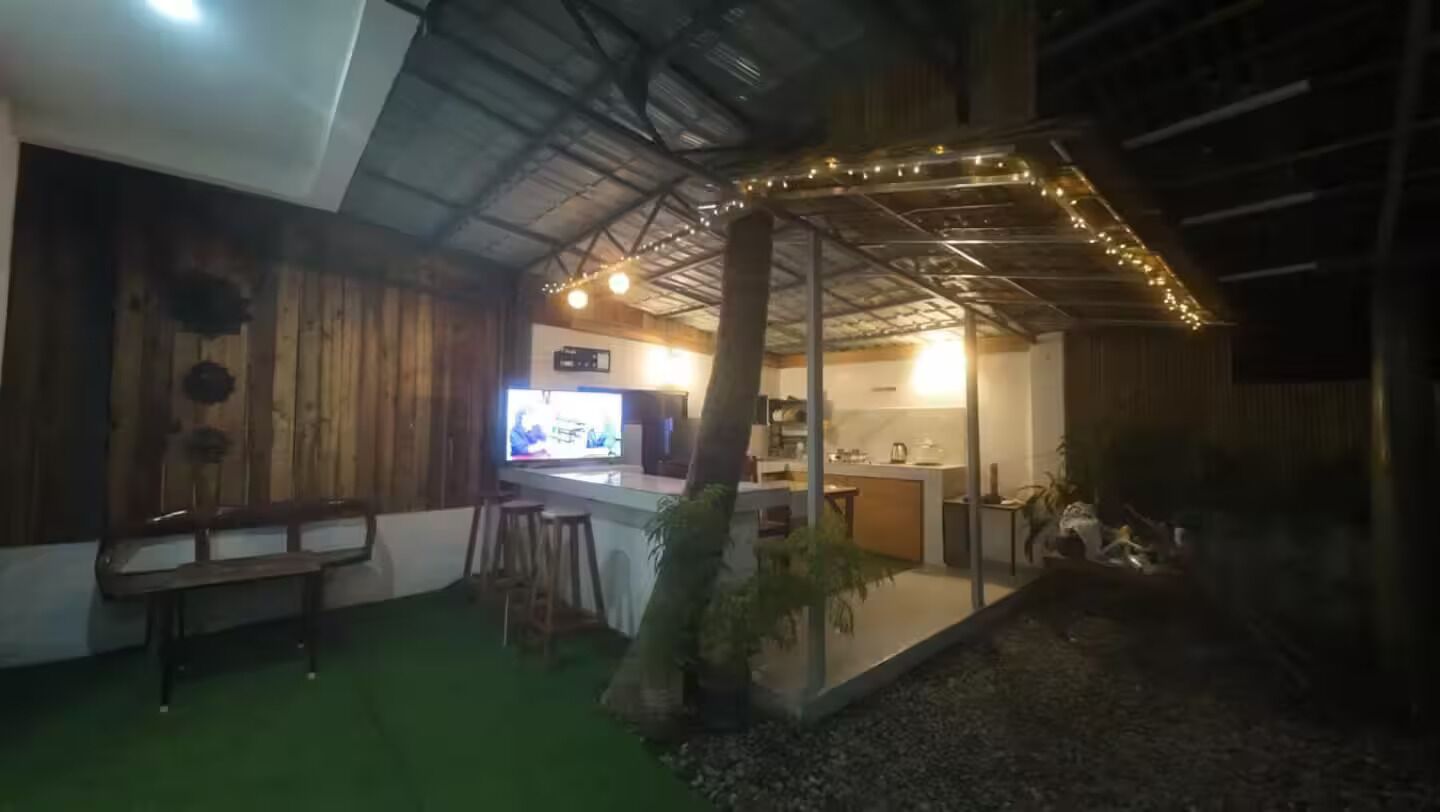 A cozy indoor space with a bar area, seating, and a small garden.