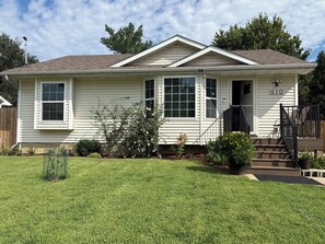A single-story house with a front porch, a number '610' on the door, and a well-maintained lawn.