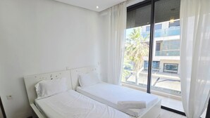 Un dormitorio moderno con una cama grande, una lámpara de techo y vistas al exterior.