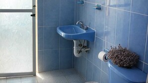 A bathroom with blue tiles, a sink, a toilet, and a shower. - Stay at Casa Alixchel 6 minutes from the Zocalo (Oaxaca de Juárez)
