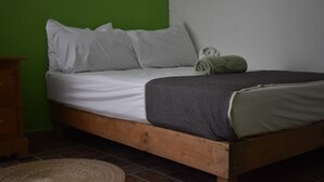A single bed with white bedding, a grey patterned blanket, and two rolled towels. - Stay at Casa Alixchel 6 minutes from the Zocalo (Oaxaca de Juárez)