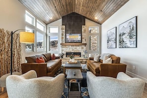 A cozy living room with a fireplace, leather sofas, and a stone accent wall. - Luxury Mountain Home • Views + Hot Tub (Winter Park)