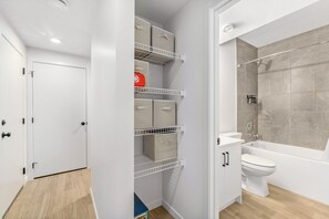 Une salle de bain moderne équipée d’une douche, de toilettes et d’étagères de rangement.