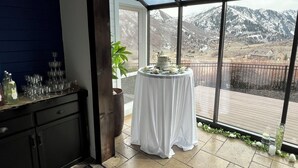 Una habitación con un amplio ventanal, una mesa con un pastel y una planta.