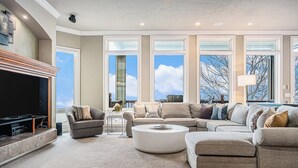 Ein geräumiges Wohnzimmer mit einem großen Ecksofa, einem Couchtisch und einem Flachbildfernseher.